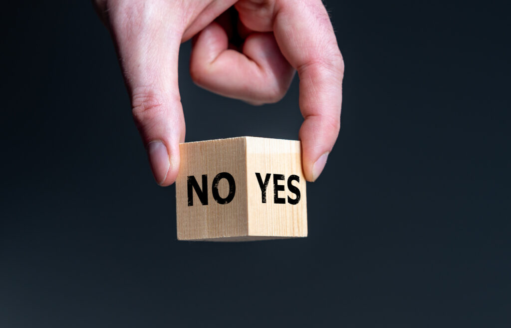 Symbol for the decision. Wooden cube with words 'yes' and 'no'. Retake a vote?