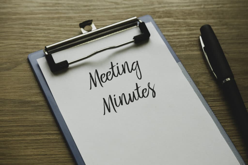 table with clip board pen paper with words "Meeting Mintues" parliamentary procedure